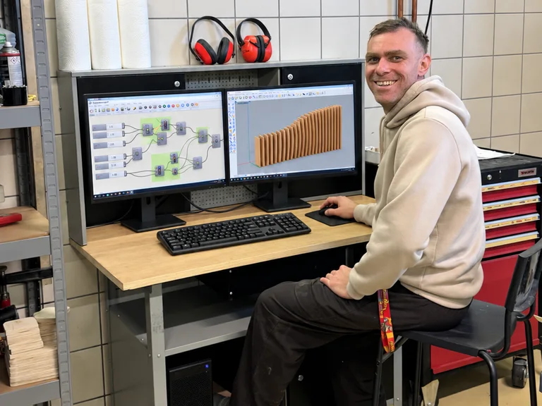 Björn at the studio workstation with a parametric node graph on one screen and the ribbed model on the other
